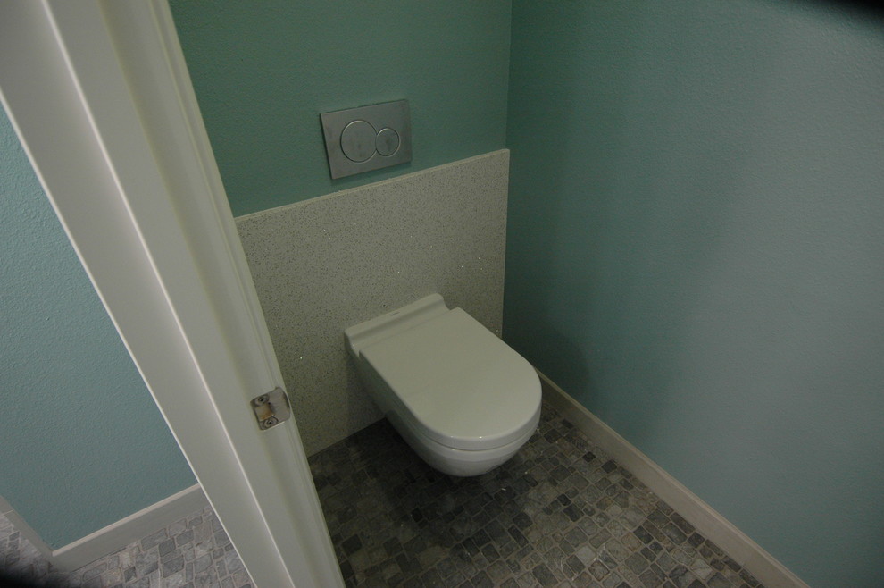 Idéer för mellanstora funkis en-suite badrum, med luckor med infälld panel, svarta skåp, en kantlös dusch, en vägghängd toalettstol, flerfärgad kakel, porslinskakel, blå väggar, klinkergolv i småsten och ett fristående handfat
