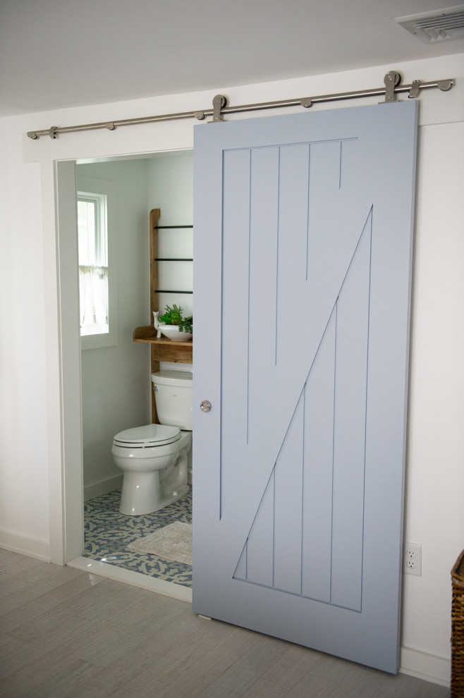 Alcove shower - small coastal 3/4 cement tile floor and multicolored floor alcove shower idea in New York with furniture-like cabinets, white cabinets, a two-piece toilet, white walls, an undermount sink, quartz countertops, a hinged shower door and white countertops