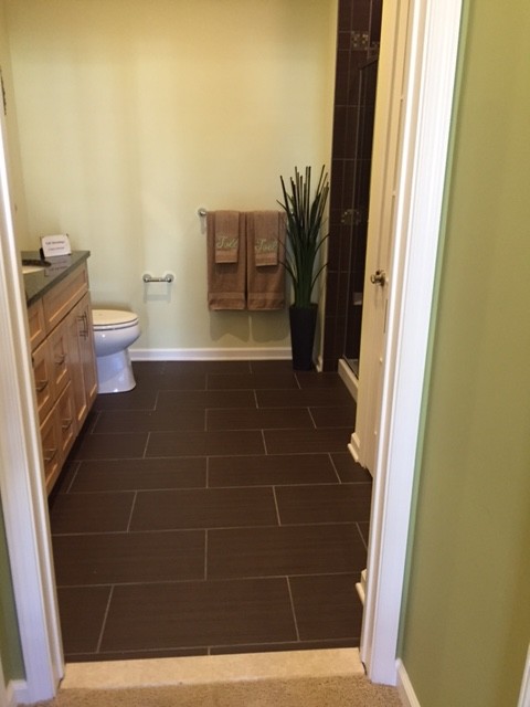 Réalisation d'une salle d'eau tradition en bois clair de taille moyenne avec un placard à porte shaker, une douche d'angle, WC séparés, un mur vert, un sol en vinyl, un lavabo encastré et un plan de toilette en surface solide.