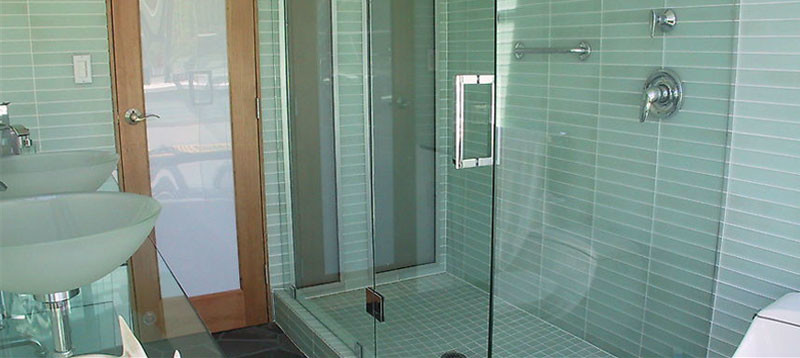 На фото: ванная комната среднего размера с настольной раковиной, стеклянной столешницей, угловым душем, зеленой плиткой, керамической плиткой, зелеными стенами, полом из сланца и душевой кабиной с