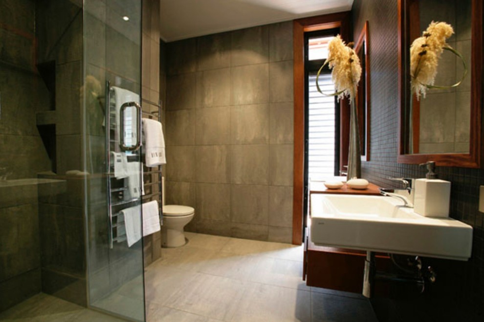 Réalisation d'une salle de bain principale design de taille moyenne avec WC séparés, un carrelage gris, un lavabo suspendu et une cabine de douche à porte battante.