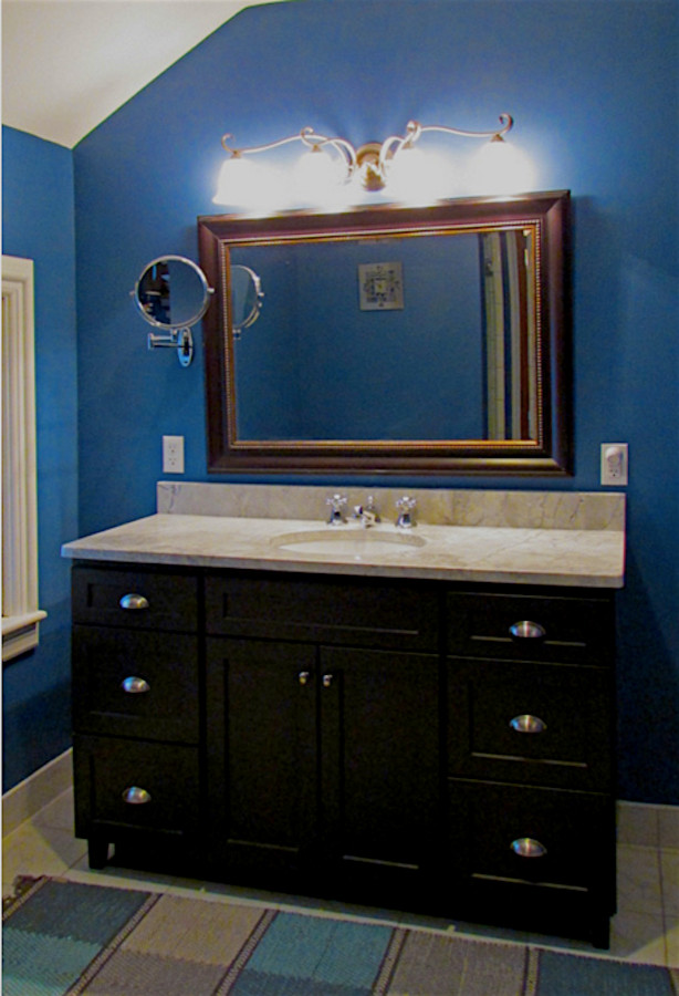Idée de décoration pour une salle d'eau tradition de taille moyenne avec un placard à porte shaker, des portes de placard noires, un mur bleu, un sol en carrelage de céramique, un lavabo encastré et un plan de toilette en marbre.