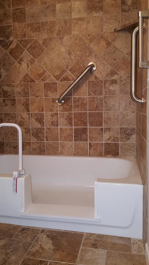 Exemple d'une salle de bain chic de taille moyenne avec une baignoire en alcôve, un combiné douche/baignoire, un carrelage beige, un carrelage marron, du carrelage en travertin, un mur marron, un sol en travertin et un sol marron.