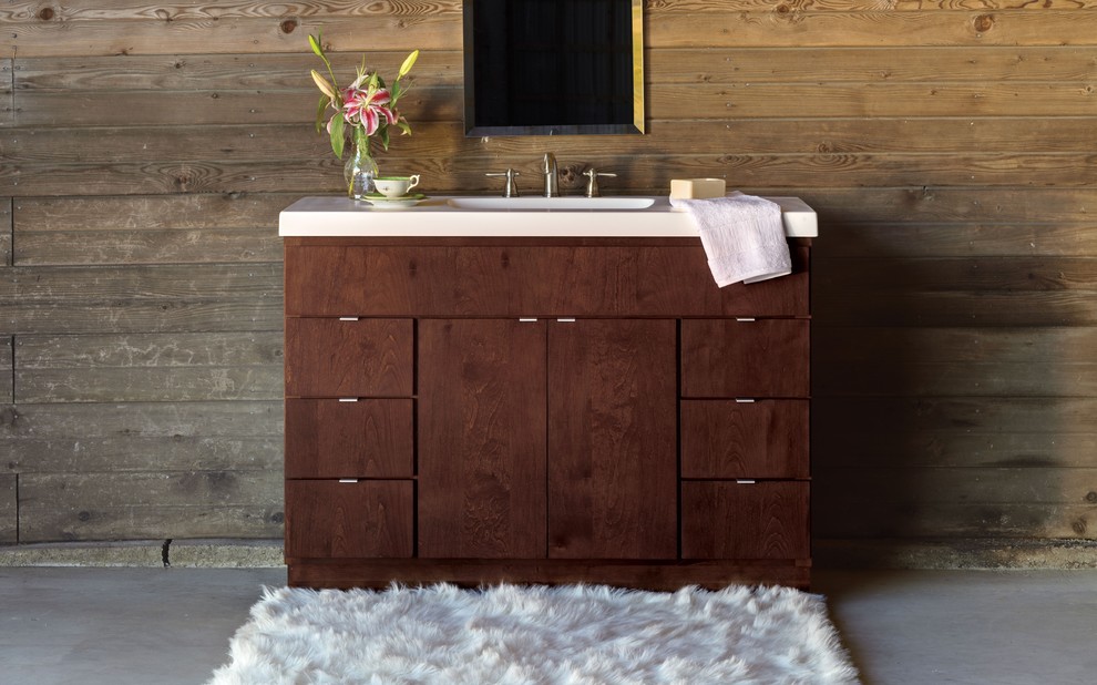 Exempel på ett rustikt badrum, med släta luckor, skåp i mörkt trä, bruna väggar, betonggolv, ett integrerad handfat, bänkskiva i akrylsten och grått golv