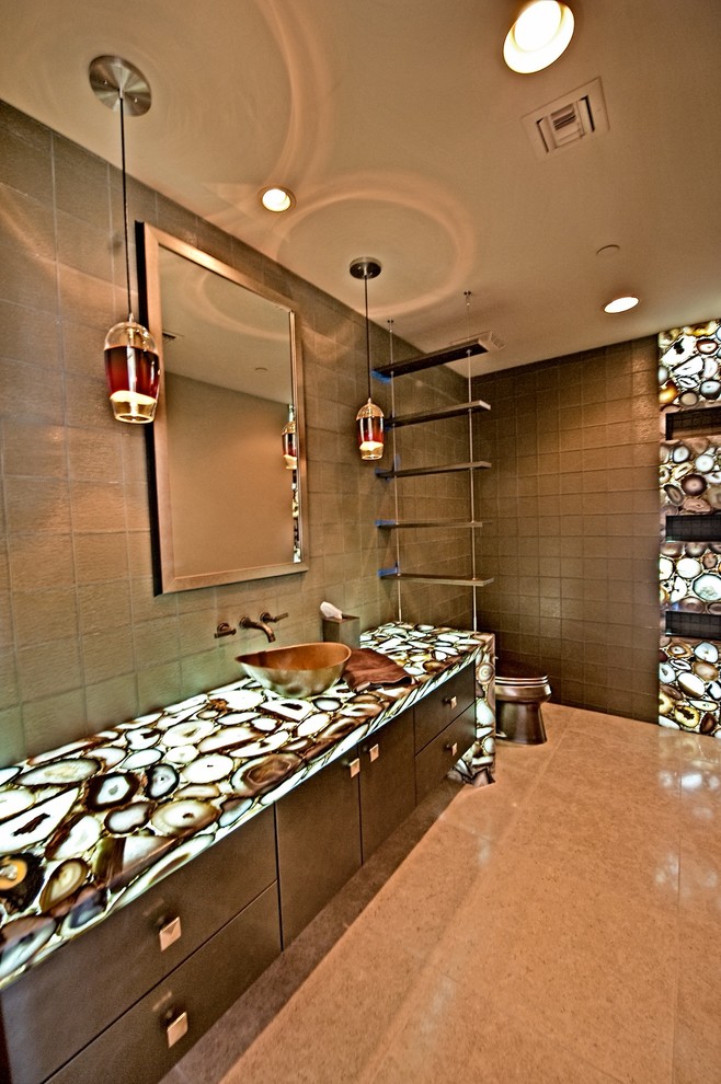 Cette image montre une grande salle de bain principale design en bois foncé avec un placard à porte plane, WC à poser, un carrelage marron, des carreaux de céramique, un mur marron, un sol en carrelage de céramique, une vasque, un plan de toilette en onyx et un sol beige.