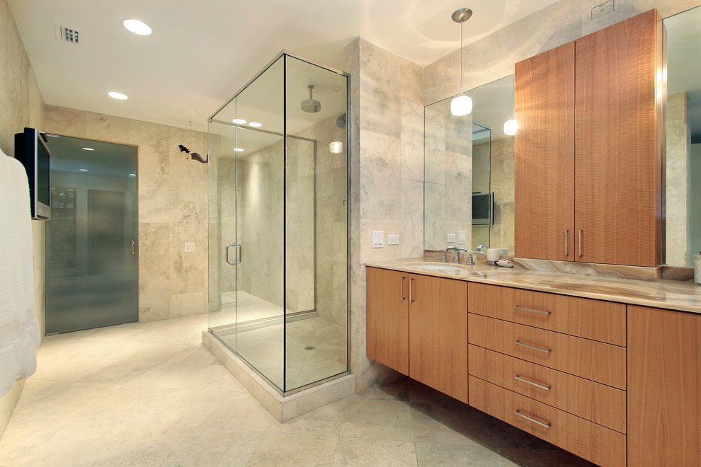 Large trendy master limestone floor corner shower photo in San Diego with flat-panel cabinets, light wood cabinets, beige walls and an undermount sink