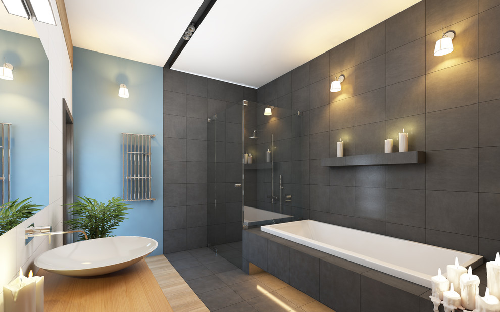 Large modern ensuite bathroom in Toronto with flat-panel cabinets, light wood cabinets, a corner shower, a two-piece toilet, a built-in bath, blue walls, bamboo flooring, a vessel sink, wooden worktops, grey tiles, porcelain tiles, grey floors and a hinged door.