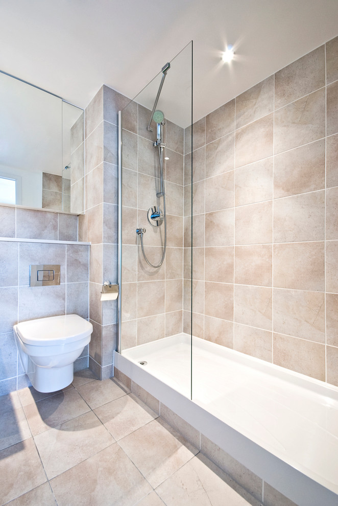 Cette image montre une grande salle de bain principale minimaliste avec une douche d'angle, WC suspendus, un mur beige et un sol en travertin.