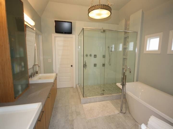 На фото: большая главная ванная комната в современном стиле с плоскими фасадами, светлыми деревянными фасадами, угловым душем, белой плиткой, плиткой кабанчик, белыми стенами, полом из керамогранита, накладной раковиной, столешницей из гранита и отдельно стоящей ванной с