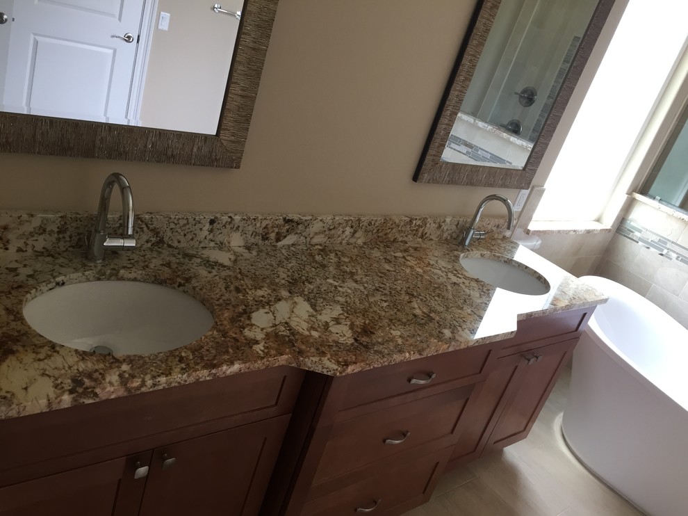 Design ideas for a medium sized classic ensuite bathroom in Miami with shaker cabinets, medium wood cabinets, a freestanding bath, an alcove shower, beige walls, a submerged sink, granite worktops, beige floors and brown worktops.