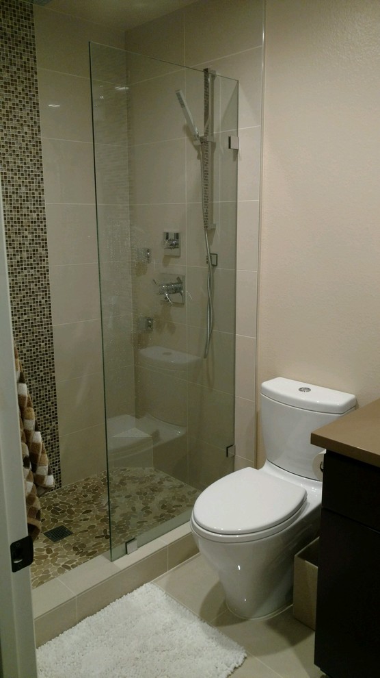 Corner shower - small contemporary 3/4 beige tile and mosaic tile ceramic tile corner shower idea in San Diego with flat-panel cabinets, dark wood cabinets, a two-piece toilet, beige walls and laminate countertops