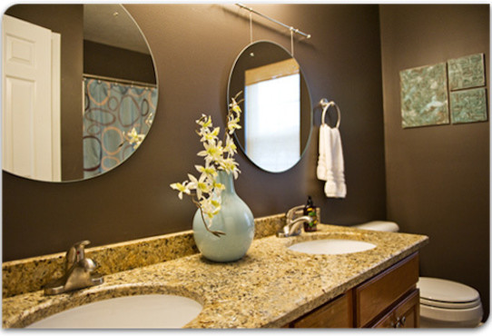 На фото: ванная комната среднего размера с накладной раковиной, фасадами с выступающей филенкой, фасадами цвета дерева среднего тона, столешницей из гранита, унитазом-моноблоком, коричневыми стенами и душевой кабиной