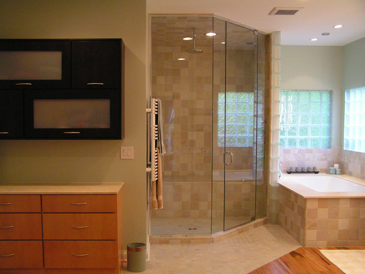 Design ideas for a large contemporary ensuite bathroom in Indianapolis with flat-panel cabinets, light wood cabinets, a submerged bath, a corner shower, beige tiles, ceramic tiles, green walls, medium hardwood flooring and a vessel sink.