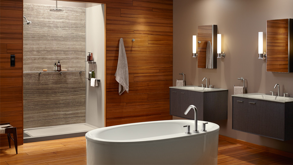 Cette image montre une douche en alcôve principale design de taille moyenne avec un lavabo intégré, un placard avec porte à panneau encastré, des portes de placard grises, une baignoire indépendante, un mur beige et un sol en bois brun.