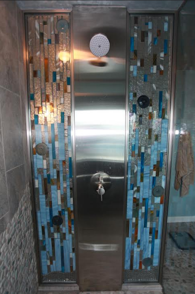 フィラデルフィアにある広いコンテンポラリースタイルのおしゃれなマスターバスルーム (フラットパネル扉のキャビネット、濃色木目調キャビネット、バリアフリー、分離型トイレ、青い壁、玉石タイル、ベッセル式洗面器、ガラスの洗面台、開き戸のシャワー) の写真