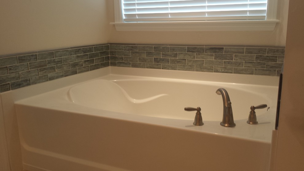 Ejemplo de cuarto de baño principal tradicional renovado de tamaño medio con bañera empotrada, baldosas y/o azulejos grises y paredes blancas