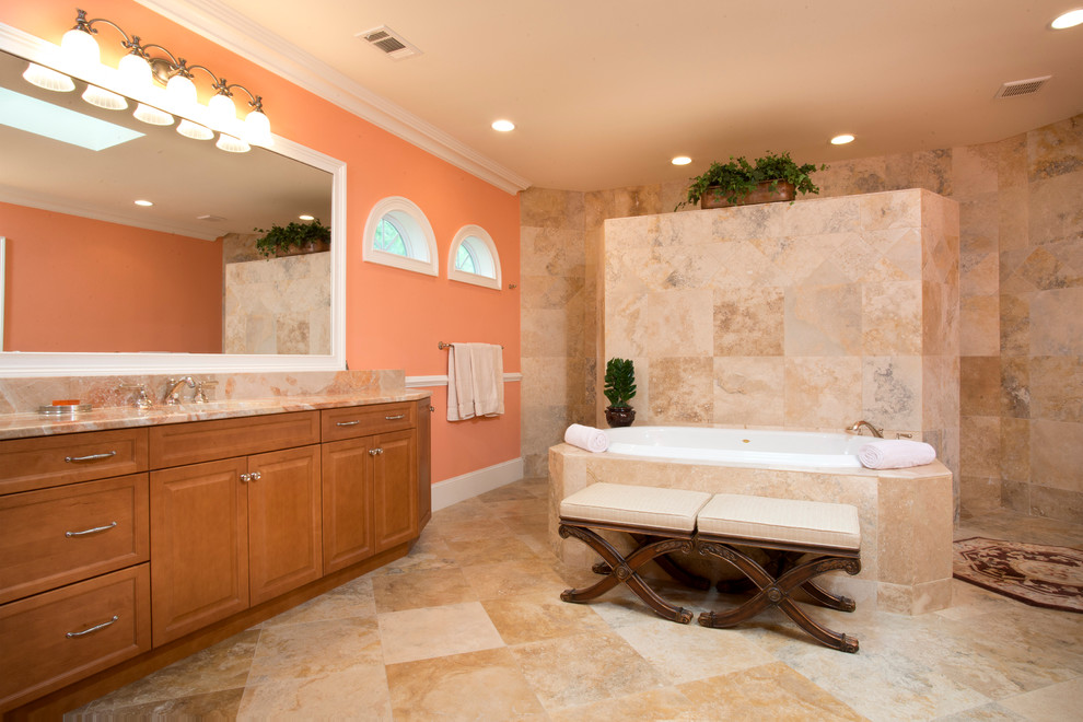 Réalisation d'une salle de bain principale ethnique en bois clair avec un lavabo encastré, un placard avec porte à panneau encastré, une baignoire posée, une douche ouverte et un mur orange.