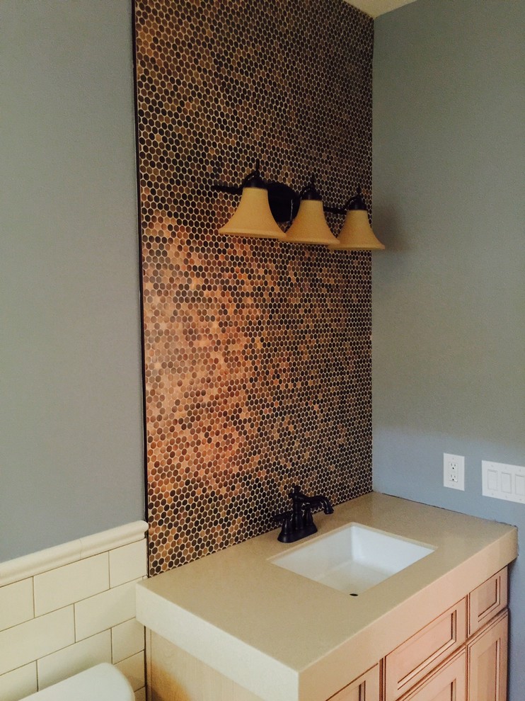 Aménagement d'une salle de bain contemporaine en bois clair avec un placard avec porte à panneau encastré, carrelage en métal et un mur gris.
