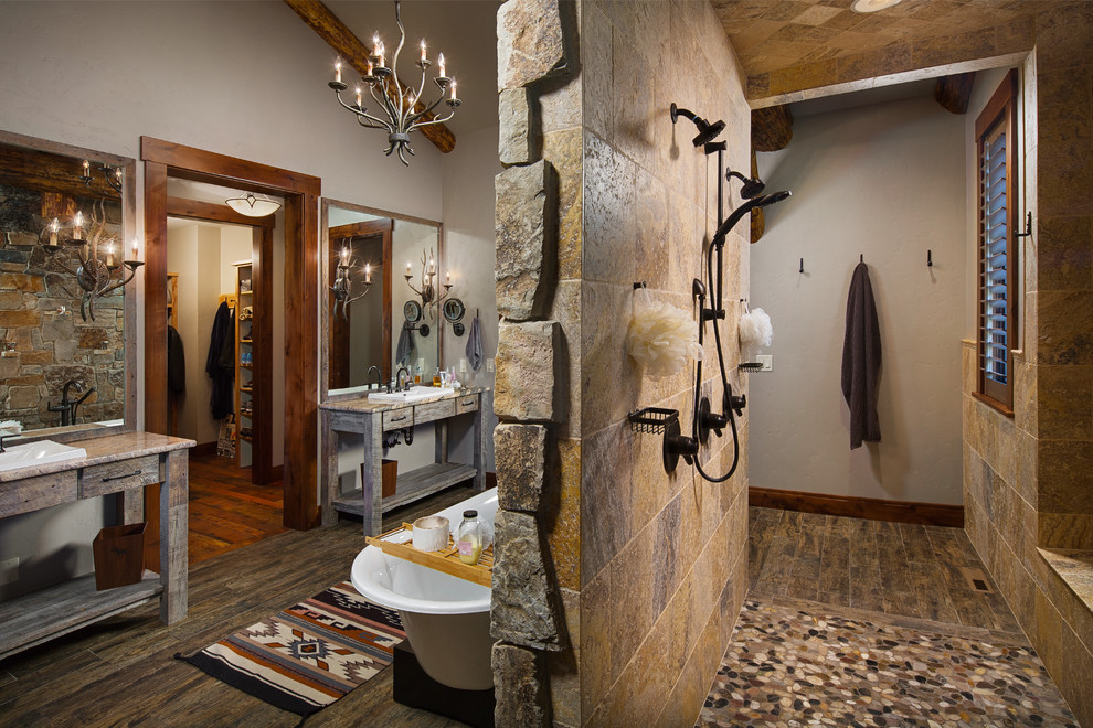 Large rustic ensuite bathroom in Other with open cabinets, distressed cabinets, a freestanding bath, a walk-in shower, brown tiles, white walls, a built-in sink, an open shower, stone tiles, porcelain flooring, granite worktops and brown floors.