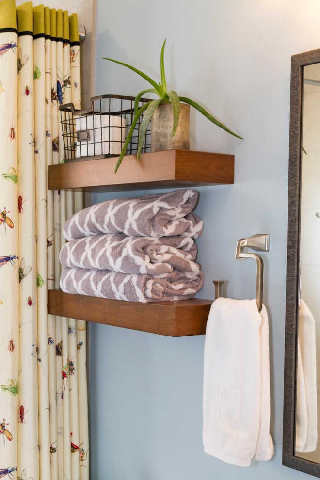 Exempel på ett litet amerikanskt svart svart badrum för barn, med luckor med infälld panel, skåp i mellenmörkt trä, ett undermonterat badkar, en dusch/badkar-kombination, en toalettstol med separat cisternkåpa, svart och vit kakel, porslinskakel, blå väggar, tegelgolv, ett undermonterad handfat, bänkskiva i kvarts, rött golv och dusch med duschdraperi