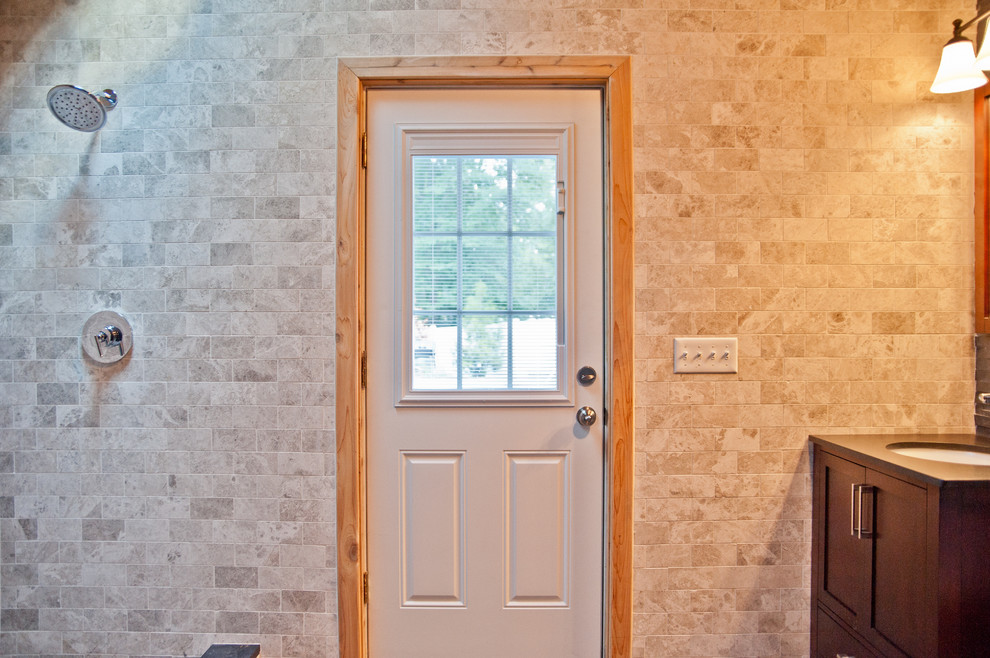 Idée de décoration pour une grande salle d'eau design en bois foncé avec un placard à porte shaker, une douche ouverte, WC à poser, un carrelage beige, un carrelage gris, un carrelage de pierre, un mur multicolore, un sol en ardoise, un lavabo encastré et un plan de toilette en surface solide.