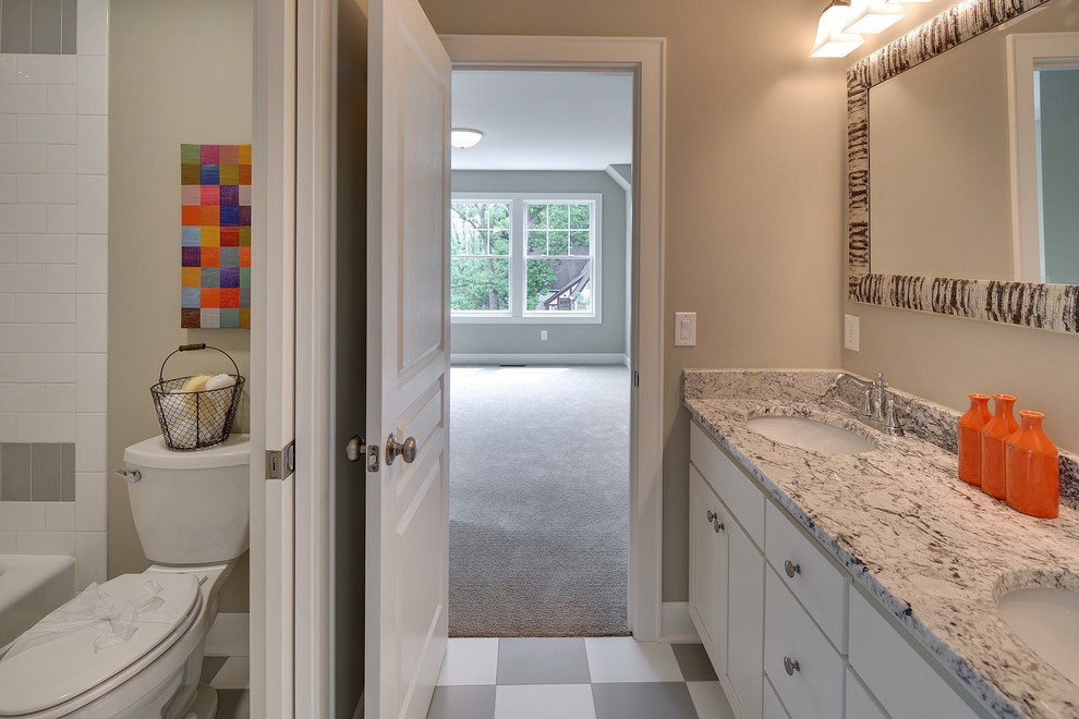Example of a large classic kids' beige tile and ceramic tile ceramic tile bathroom design in Minneapolis with an integrated sink, flat-panel cabinets, white cabinets, granite countertops and a one-piece toilet