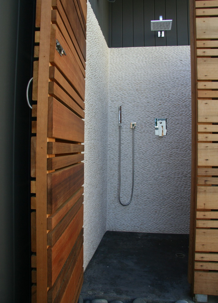 Ejemplo de cuarto de baño retro de tamaño medio con ducha esquinera, baldosas y/o azulejos blancos, suelo de baldosas tipo guijarro y suelo de cemento