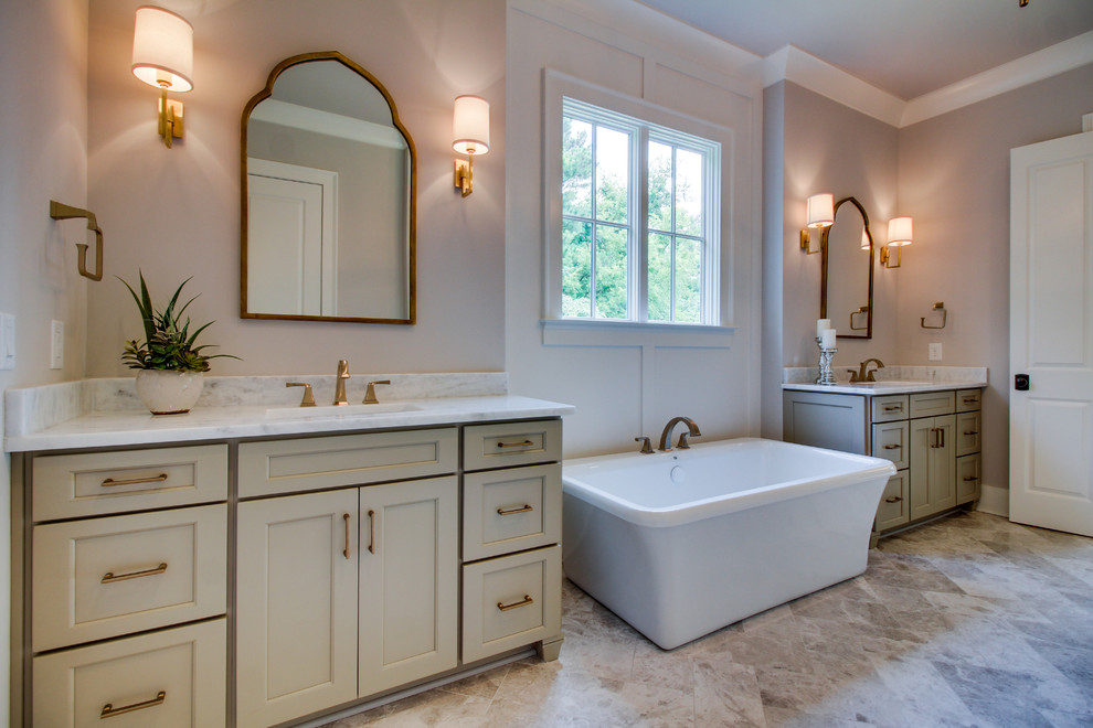 Large classic ensuite bathroom in Nashville with beaded cabinets, beige cabinets, a freestanding bath, pink walls, vinyl flooring, a submerged sink and marble worktops.