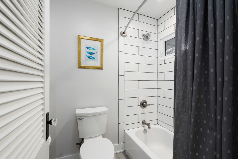 Foto di una piccola stanza da bagno tradizionale con vasca ad alcova, vasca/doccia, piastrelle bianche, piastrelle in ceramica, pareti bianche e doccia con tenda