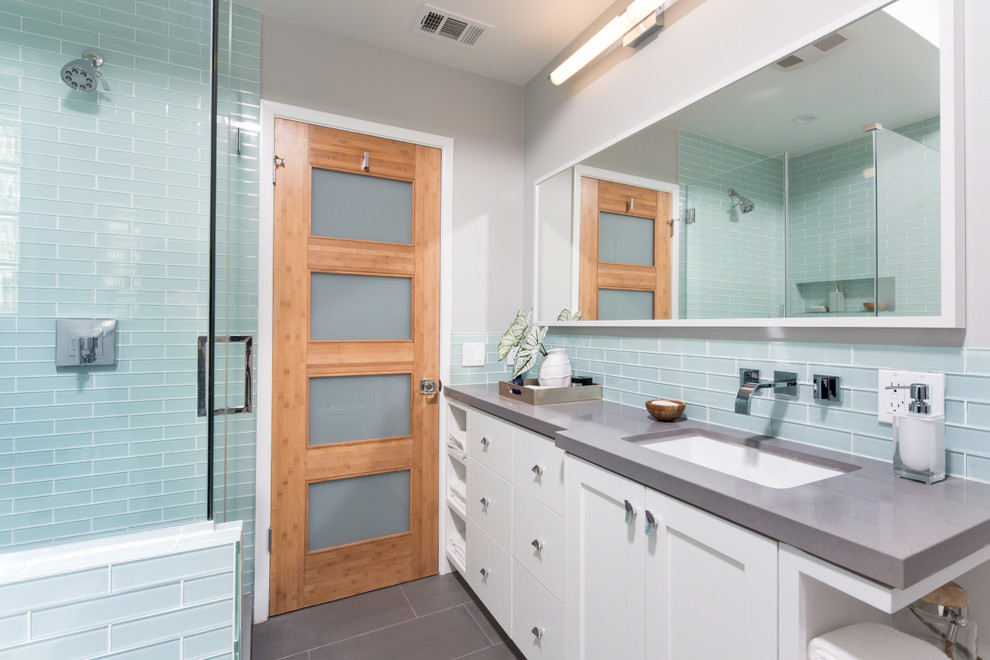 На фото: ванная комната в стиле неоклассика (современная классика) с врезной раковиной, фасадами в стиле шейкер, белыми фасадами, синей плиткой, серыми стенами и серой столешницей с