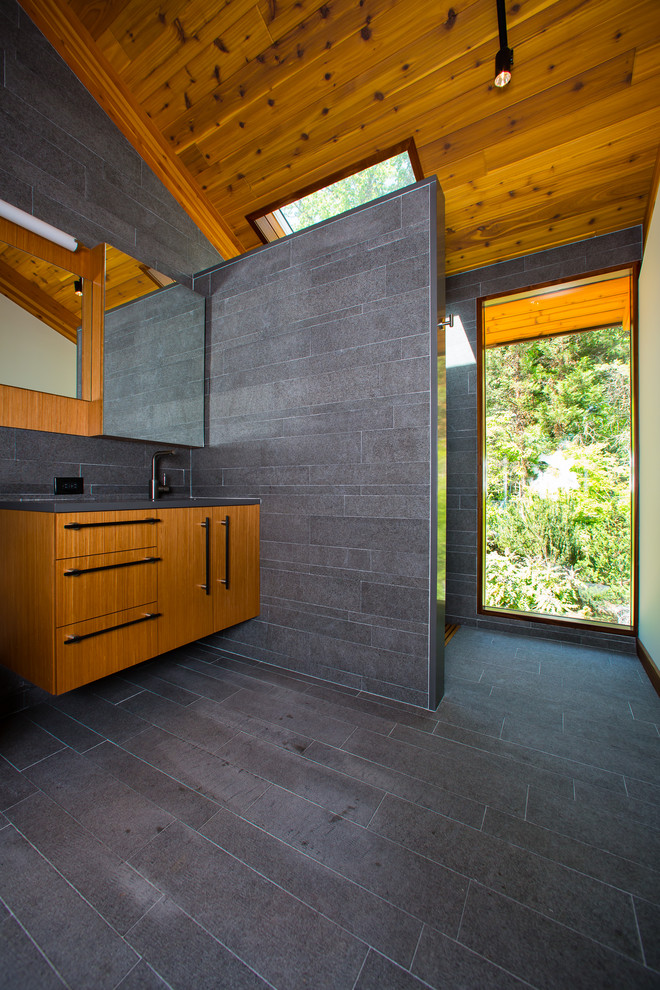 Inspiration för mellanstora moderna en-suite badrum, med en kantlös dusch, släta luckor, skåp i mellenmörkt trä, grå kakel, porslinskakel, grå väggar, klinkergolv i porslin, ett undermonterad handfat, bänkskiva i akrylsten, grått golv och med dusch som är öppen