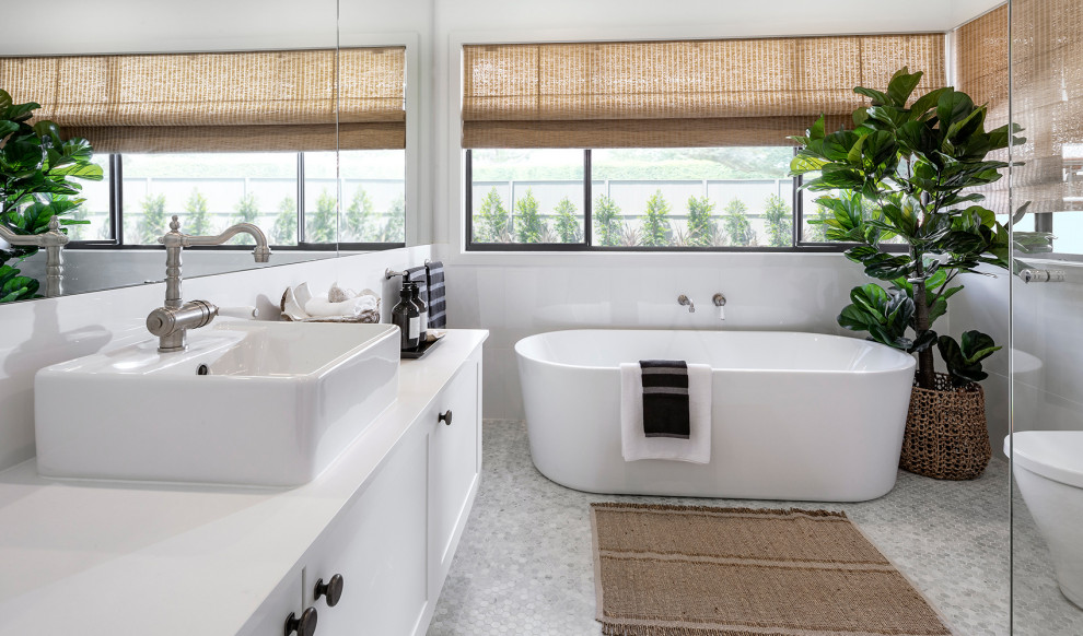 Exemple d'une grande salle de bain principale tendance avec un placard à porte shaker, des portes de placard blanches, une baignoire indépendante, une douche d'angle, un carrelage blanc, des plaques de verre, un mur blanc, une vasque, un sol gris, un plan de toilette blanc, meuble double vasque et meuble-lavabo encastré.