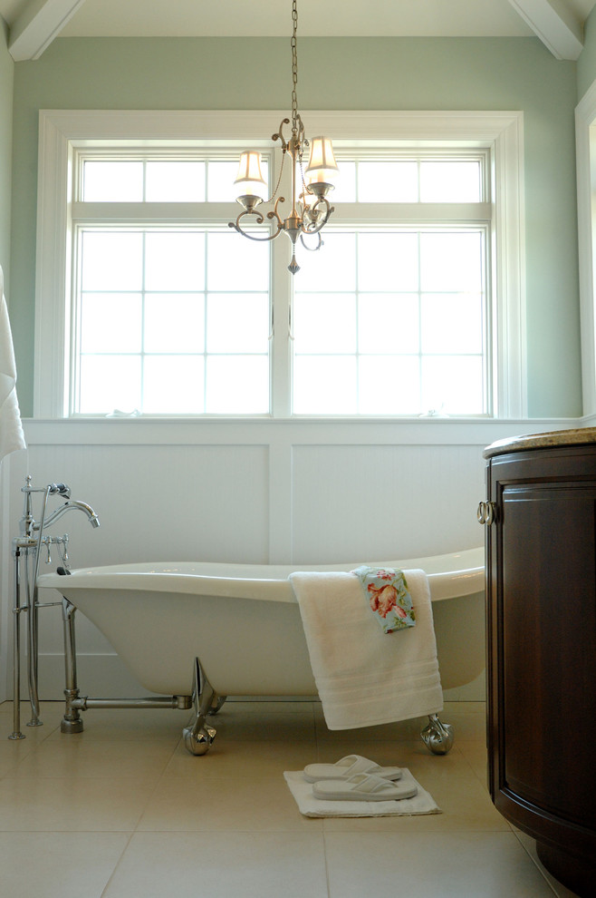 На фото: ванная комната в классическом стиле с ванной на ножках с