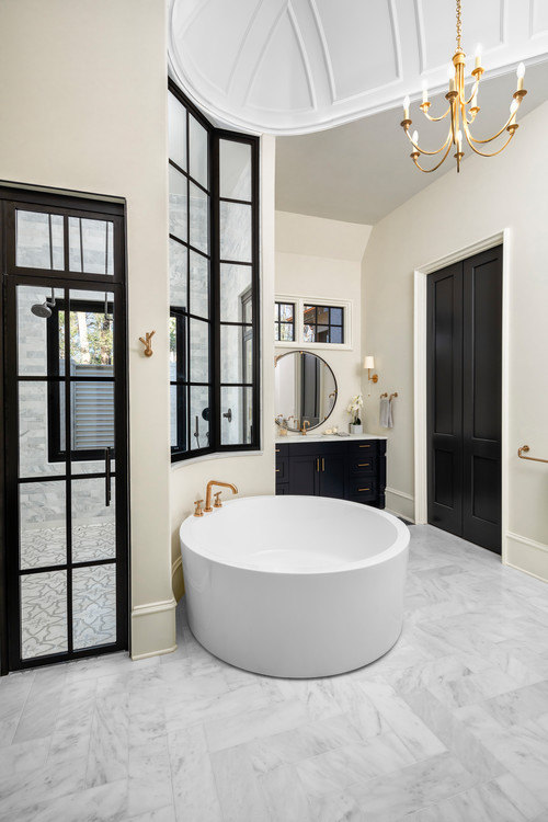 Elegant bathroom with Black Bathroom Cabinets, round freestanding tub, marble floor, and gold fixtures under vaulted ceiling