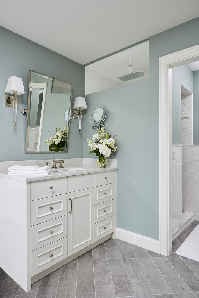Inspiration pour une salle de bain principale traditionnelle de taille moyenne avec un placard avec porte à panneau encastré, des portes de placard blanches, une baignoire indépendante, un mur bleu, un sol en carrelage de céramique, un lavabo encastré, un plan de toilette en granite et un sol gris.