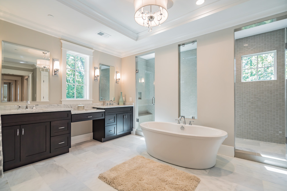 Inspiration for a large timeless master white tile and marble tile marble floor bathroom remodel in DC Metro with recessed-panel cabinets, dark wood cabinets, a two-piece toilet, beige walls, an integrated sink and marble countertops