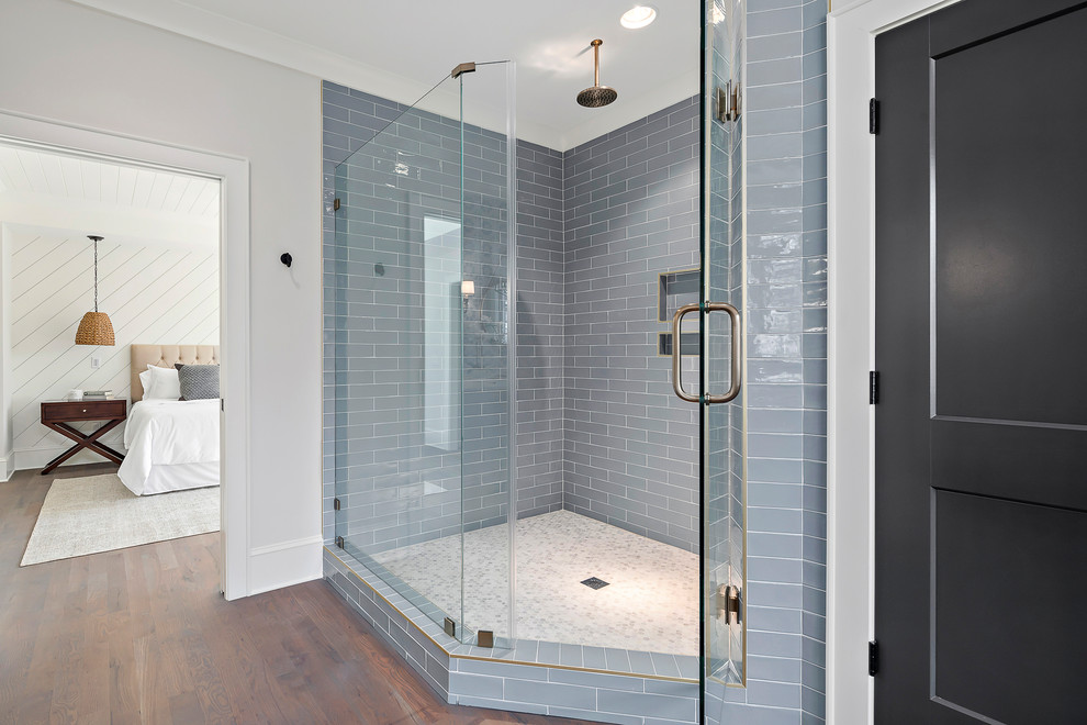 Design ideas for a large rural ensuite bathroom in Charlotte with a corner shower, blue tiles, metro tiles, beige walls, medium hardwood flooring, brown floors and a hinged door.