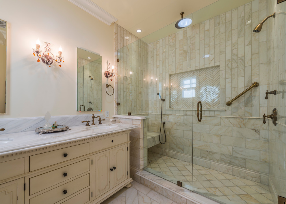 Mid-sized elegant master beige tile and marble tile marble floor and beige floor alcove shower photo in Los Angeles with recessed-panel cabinets, distressed cabinets, beige walls, an undermount sink, marble countertops and a hinged shower door