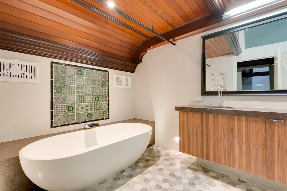 Ispirazione per una stanza da bagno industriale con lavabo sottopiano, top in quarzo composito, vasca freestanding e piastrelle in gres porcellanato