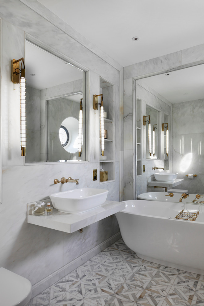 Inspiration för ett stort funkis vit vitt en-suite badrum, med vita skåp, ett fristående badkar, marmorkakel, marmorgolv, flerfärgat golv, en vägghängd toalettstol, grå kakel och ett fristående handfat