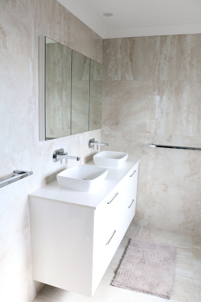 Example of a large trendy 3/4 beige tile and porcelain tile porcelain tile and beige floor doorless shower design in Brisbane with beige walls, a vessel sink, solid surface countertops, a hinged shower door and white countertops
