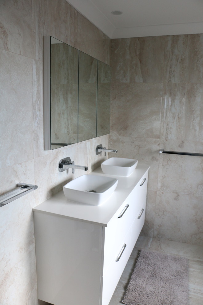 Bild på ett stort funkis vit vitt badrum med dusch, med en öppen dusch, beige kakel, porslinskakel, beige väggar, klinkergolv i porslin, ett fristående handfat, bänkskiva i akrylsten, beiget golv och dusch med gångjärnsdörr