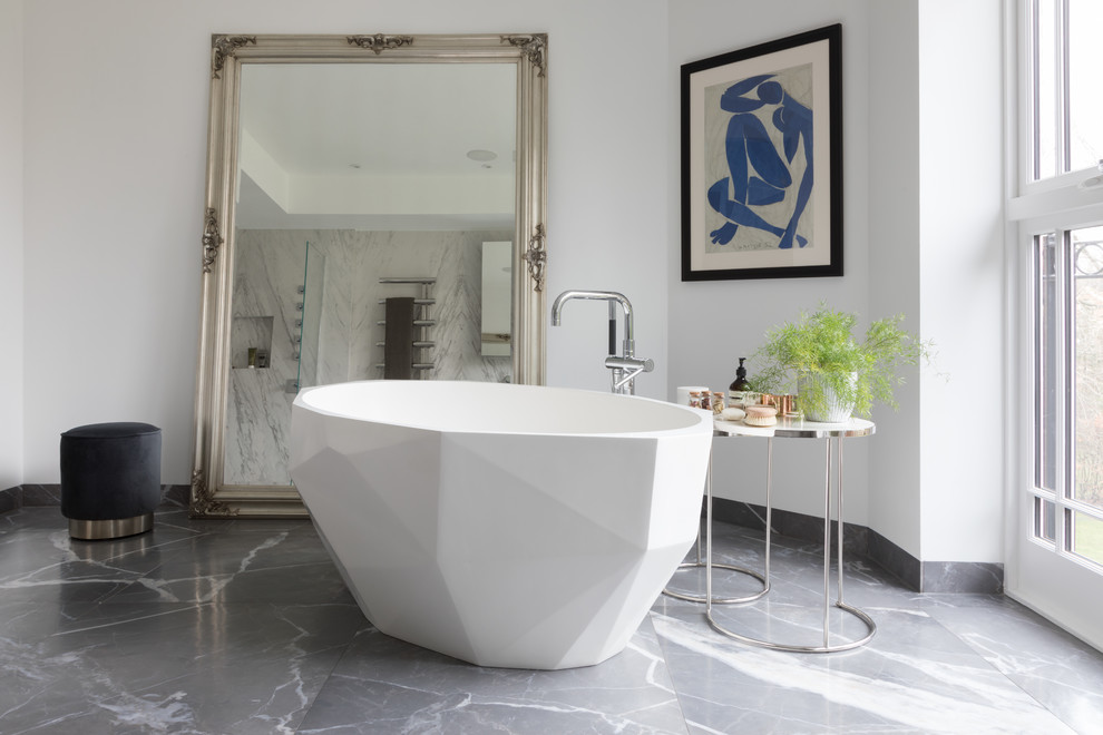 Foto di una stanza da bagno minimal con vasca freestanding, pareti bianche e pavimento grigio