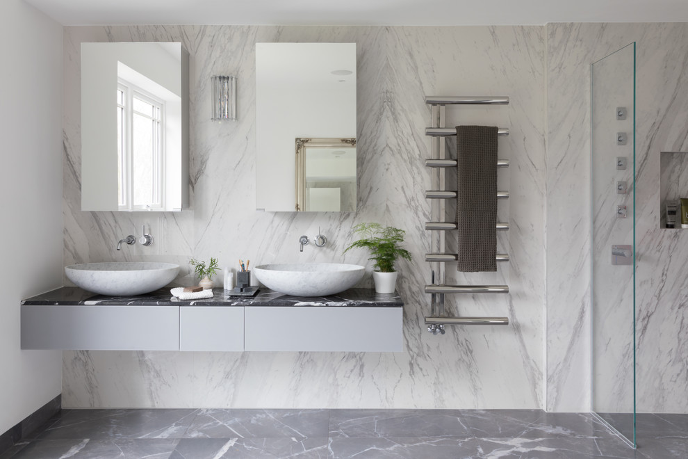 Modernes Badezimmer mit flächenbündigen Schrankfronten, grauen Schränken, weißen Fliesen, Steinplatten, Aufsatzwaschbecken, grauem Boden und schwarzer Waschtischplatte in London