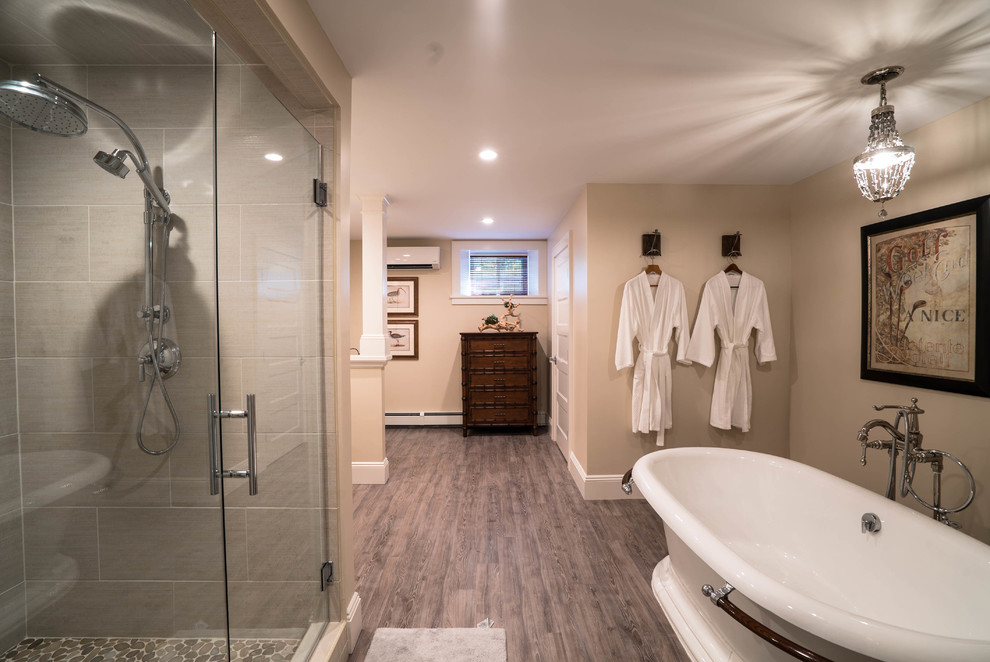 Exempel på ett stort rustikt en-suite badrum, med ett fristående badkar, en dusch i en alkov, grå kakel, stenkakel, luckor med infälld panel, skåp i mörkt trä, en toalettstol med separat cisternkåpa, beige väggar, mellanmörkt trägolv, ett undermonterad handfat, brunt golv och dusch med gångjärnsdörr