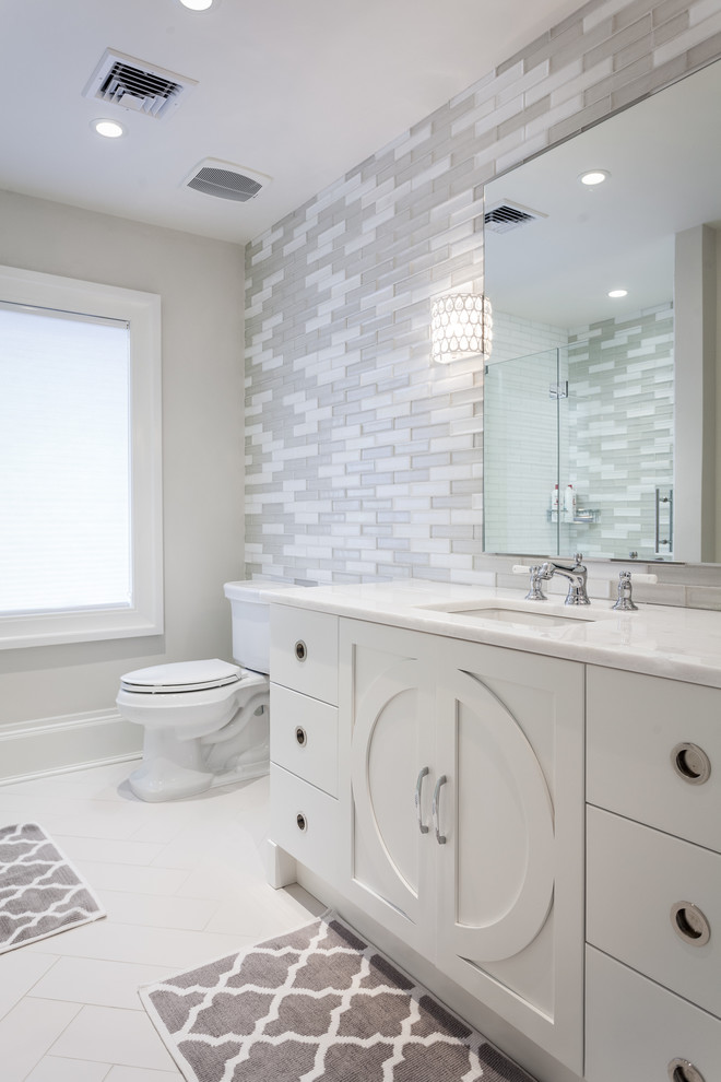 Example of a large trendy kids' gray tile and matchstick tile porcelain tile and white floor bathroom design in New York with white cabinets, flat-panel cabinets, a two-piece toilet, gray walls and an undermount sink