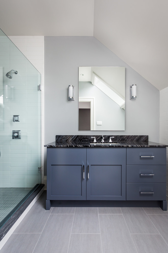 Example of a mid-sized trendy kids' white tile and porcelain tile porcelain tile and gray floor corner shower design in New York with a hinged shower door, gray cabinets, gray walls and shaker cabinets