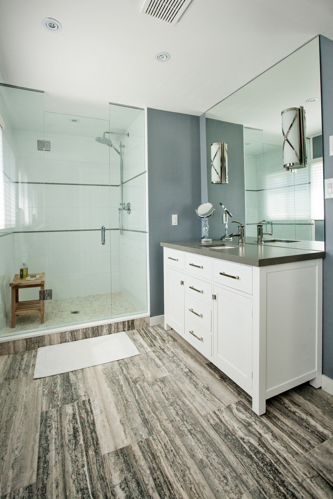 Klassisk inredning av ett mellanstort badrum, med ett undermonterad handfat, skåp i shakerstil, vita skåp, en dusch i en alkov, grå väggar, bänkskiva i kvarts, grå kakel och travertin golv
