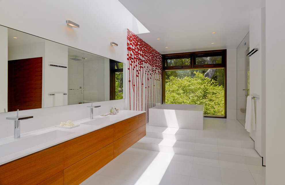 サンフランシスコにある広いモダンスタイルのおしゃれなマスターバスルーム (一体型シンク、フラットパネル扉のキャビネット、中間色木目調キャビネット、置き型浴槽、白い壁) の写真