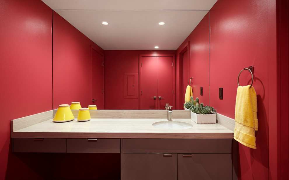 Idée de décoration pour une salle de bain design avec un placard à porte plane, des portes de placard grises, un mur rouge, un lavabo encastré, un plan de toilette beige, meuble simple vasque et meuble-lavabo encastré.